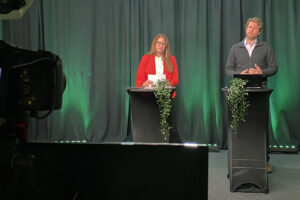 En kvinna och en man som står vid varsitt ståbord och pratar.